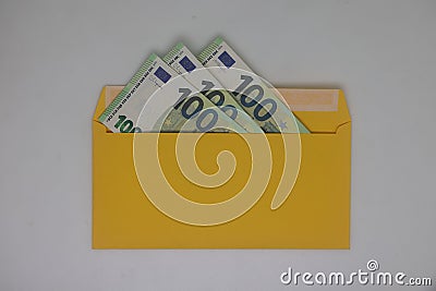 Toy house. banknotes in a yellow envelope on a light background. envelope with banknotes. close-up of an envelope with Stock Photo