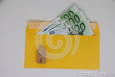 Toy house. banknotes in a yellow envelope. open envelope with banknotes on a light background. envelope with banknotes Stock Photo