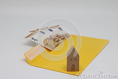 Toy house. banknotes in a yellow envelope. open envelope with banknotes on a light background. envelope with banknotes Stock Photo