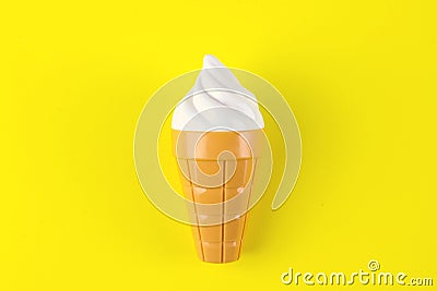 Toy ice cream on yellow background. Concept of harmful artificial food. Fast food Stock Photo