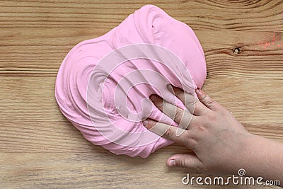 Toy for kids slime children`s hand kneads the mass of pink Stock Photo
