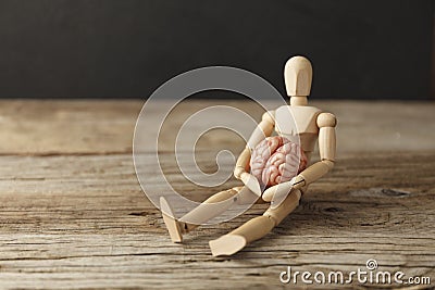 Toy man holds an anatomical brain in his hands. Care and therapy, psychological symptoms. Neuroligic diseases Stock Photo