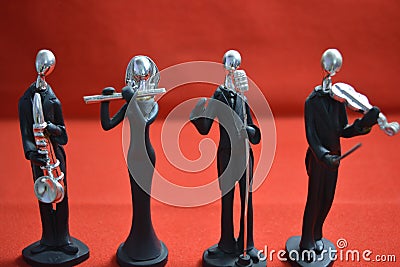 Toy Man with microphone and musicians on red background. Stock Photo