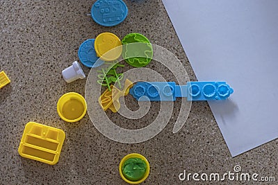 Toy molds for use with yellow and green blue plasticine. Children toys on the floor with green clay Stock Photo