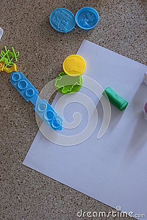 Toy molds for use with yellow and green blue plasticine. Children toys on the floor with green clay Stock Photo