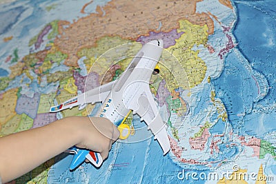 The toy plane flies by the geographical map Stock Photo