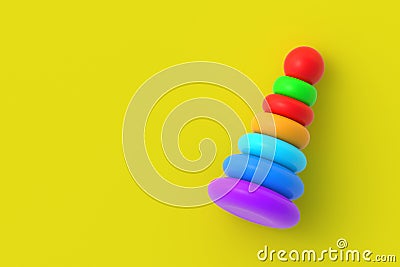 Toy pyramid tower on yellow background. Children education. Educational games. Preschool development. Copy space Stock Photo