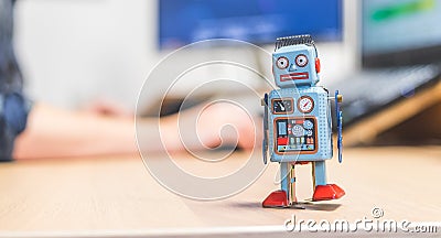 Artificial intelligence concept: Toy robot on office desktop. Metaphor for chatbot, social bot and algorithms Stock Photo
