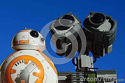 Toy robot fiends Sphero BB8 from Star Wars and LEGO Wall-E from Disney Pixar movie sunbathing on daylight sunshine, Editorial Stock Photo