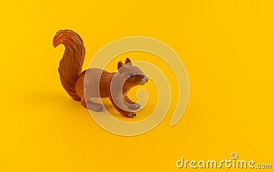 Toy squirrel from plastic on a yellow background Stock Photo