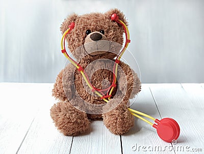 Toy stethoscope and teddy bear on wooden table. Doctor tool Stock Photo