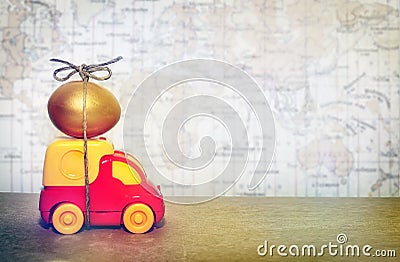 A toy truck carrying a golden egg, a symbol of the reliability of delivery of postal goods Stock Photo