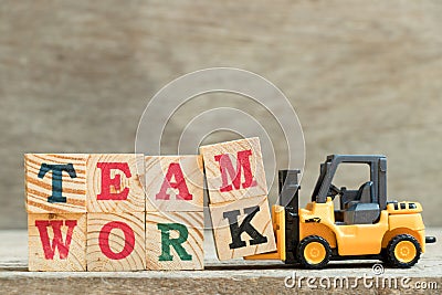Toy yellow forklift hold block letter m and k to complete word Stock Photo