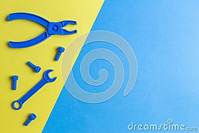 Toys background. Kids construction toys tools on blue and yellow background. Top view Stock Photo