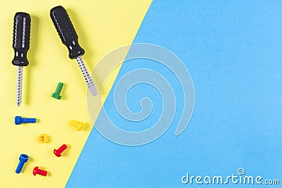 Toys background. Kids construction toys tools on light blue and yellow background. Top view Stock Photo