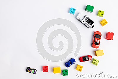 Toys constuctor and cars, top view on white background, place for text Stock Photo