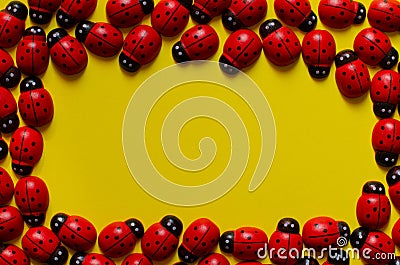 Toys frame. Wooden ladybugs frame on yellow background. Copy space. Ladybug pattern Stock Photo