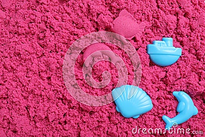 Toys on pink kinetic sand, flat lay Stock Photo