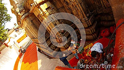 Trabalhadores e crianças tiram coisas da pilha com prasad perto de muros com estátuas de Deusa Antigo templo hindu Kamakhya Maa filme Trabalhadores e crianças tiram coisas da pilha com prasad perto de muros com estátuas de Deusa Antigo templo hindu Kamakhya Maa filme
