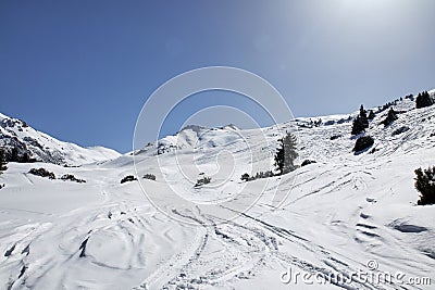 Traces of skis and snowboards in the snow, on freeride track Karakol ski resort. Mountain scenery landscape, Kyrgyzstan Stock Photo