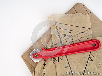 Tracing wheel and paper dressmaking pattern, home sewing items isolated on white. Stock Photo