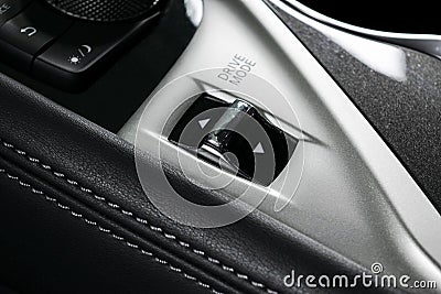 Track control buttons near automatic gear stick of a modern car in black leather interior with stitching. Car interior details. Ca Stock Photo