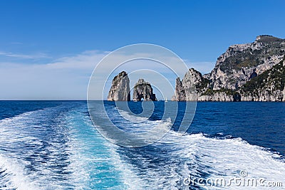 The track from the high-speed ship against the background of individual rocks in the sea- natural and travel background. Stock Photo