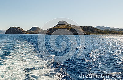 Track trail behind of speed boat on sea surface with clear sky in background Stock Photo