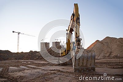 Track-type excavator during earthmoving at construction site. Backhoe digg ground at construction site for the construction Stock Photo