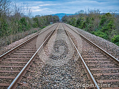 The tracks of two railway lines converge into the distance on a winter day. Editorial Stock Photo