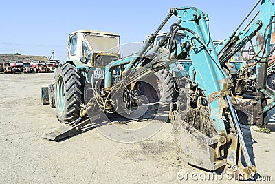 Tractor with a bucket for digging soil. Bulldozer and grader. Editorial Stock Photo