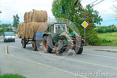 Tractor carrying bales of hay, tractor trucks twisted stacks of hay Editorial Stock Photo