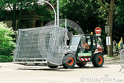 Tractor carrying metallic fence on urban street Editorial Stock Photo