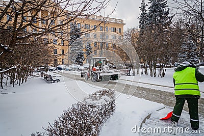 Tractor cleaning the road from the snow. Excavator cleans the st Editorial Stock Photo