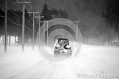A tractor cleans snow on the road Stock Photo