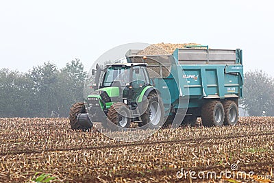 Tractor collecting the maize harvest in a large trailer Editorial Stock Photo