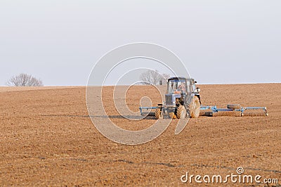 Tractor cultivates box spring Stock Photo