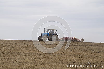 The tractor cultivates the soil in the spring Stock Photo