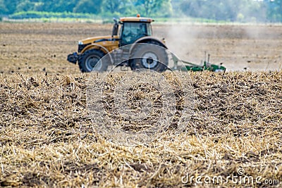 Tractor cultivating the field Stock Photo