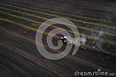 Tractor cultivating field at spring, aerial view Stock Photo