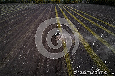 Tractor cultivating field at spring, aerial view Stock Photo