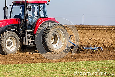Tractor cultivating field at spring Stock Photo