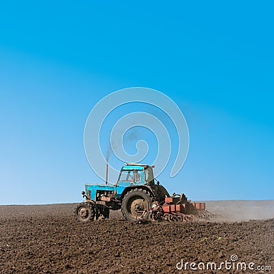 Tractor cultivating field at spring Stock Photo