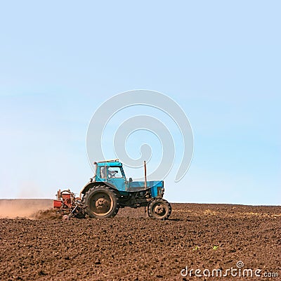 Tractor cultivating field at spring Stock Photo