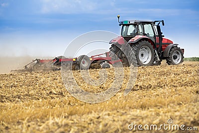 Tractor cultivating wheat stubble field, crop residue. Stock Photo