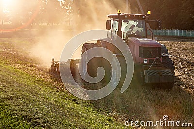 Tractor cultivator plows the land, prepares for crops. dust on field Stock Photo