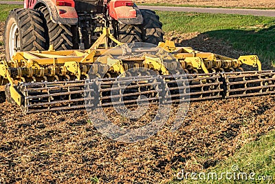 Tractor cultivator plows the land, prepares for crops. dust on field Stock Photo