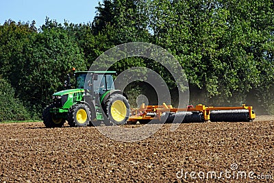 Tractor with Disc Harrow in Field Editorial Stock Photo