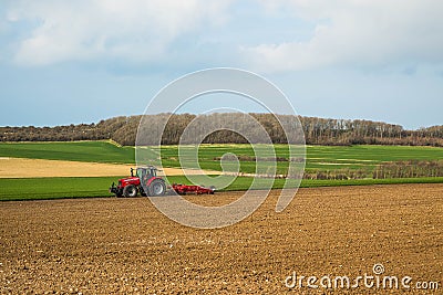 farmer with his tractor equipped with a disc plow to plow the fields Editorial Stock Photo