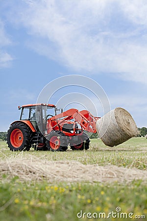 Tractor Hauling Round Bale Stock Photo